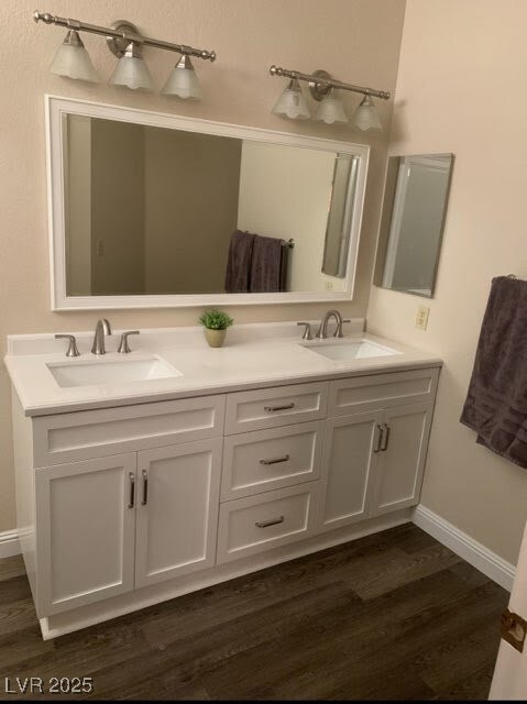 Full bathroom featuring double vanity, wood finish