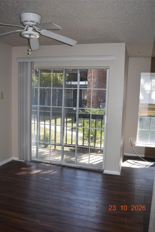 Doorway with dark wood-type flooring, a textured c
