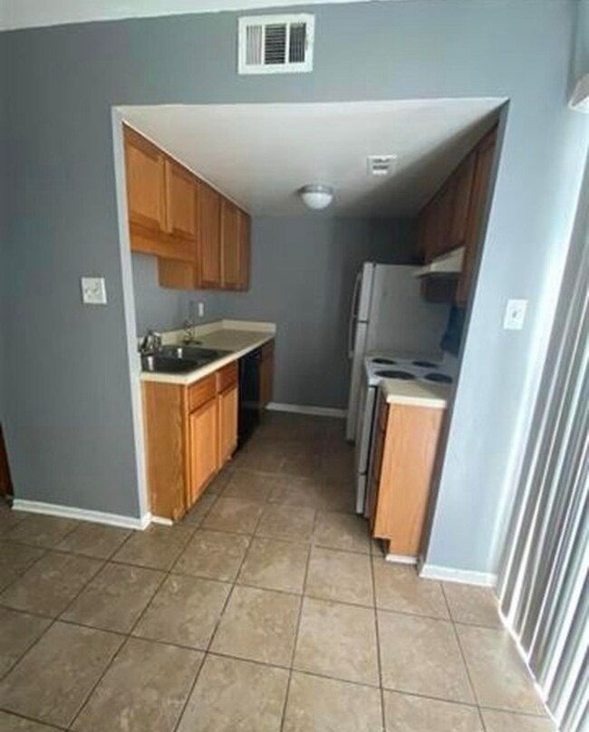 Kitchen with black dishwasher, exhaust hood, sink,