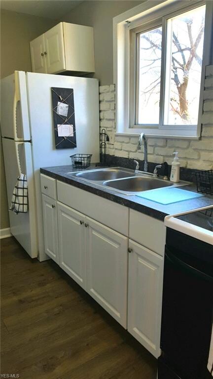 New flooring and fresh paint in kitchen including appliances