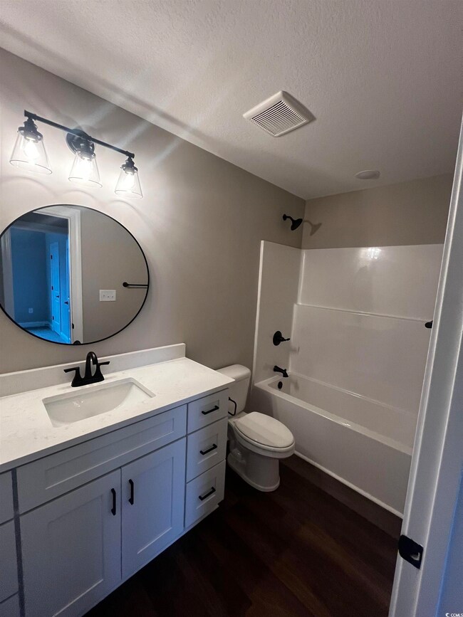 Full bath featuring wood finished floors, vanity, 
