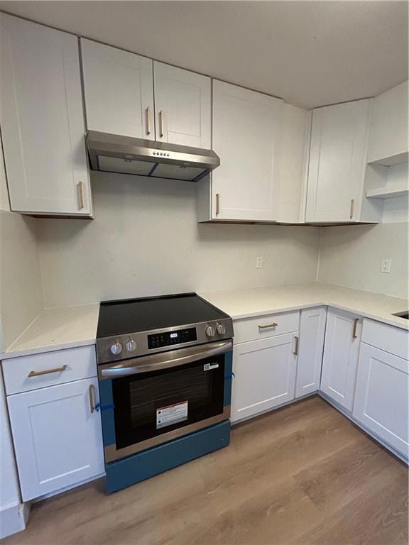 Kitchen featuring stove, white cabinetry, open shelves, and light wood-style floors