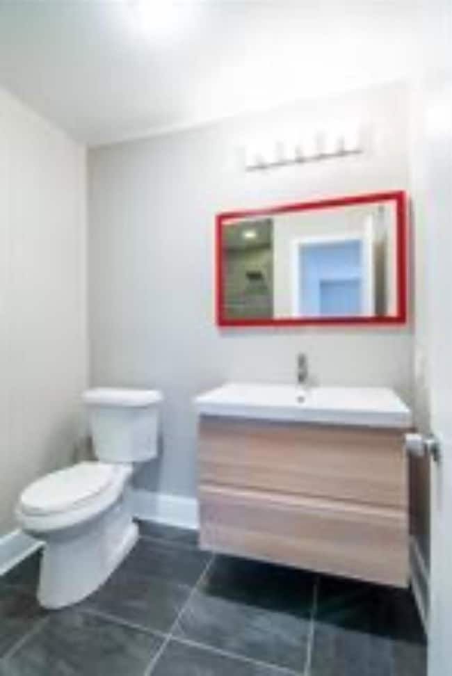 Bathroom featuring toilet, baseboards, and vanity