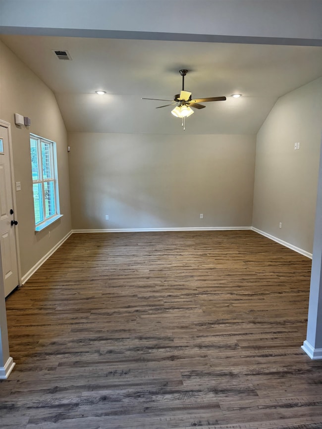 Livingroom featuring lofted ceiling, a ceiling fan, and dark wood-style flooring