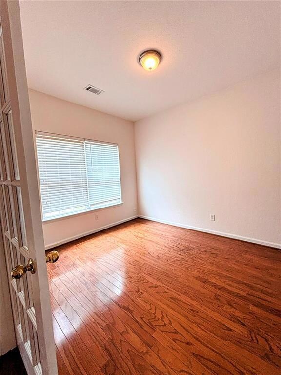 Spare room with visible vents, baseboards, and har