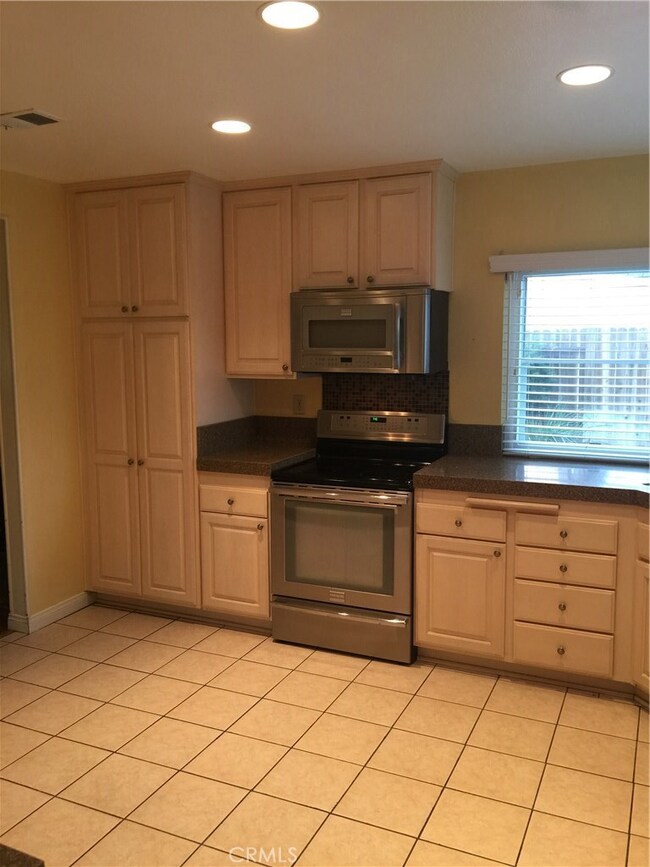Kitchen Depicting Custom Cabinetry and Stainless Steel Range, Microwave and Oven