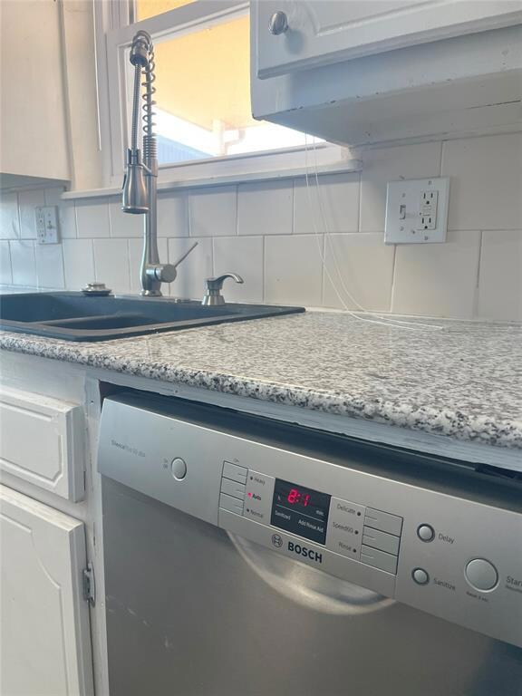 Details featuring dishwasher, light stone counters