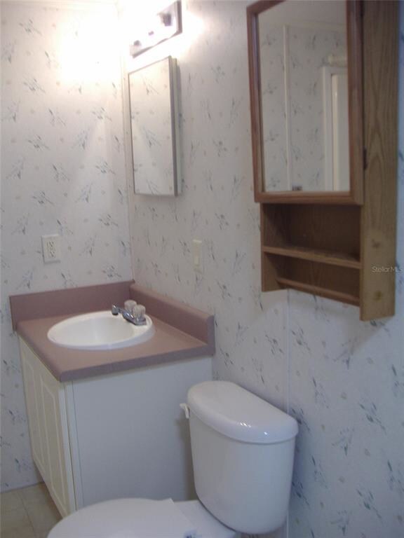 View of the sink and commode. Shower is on the oth