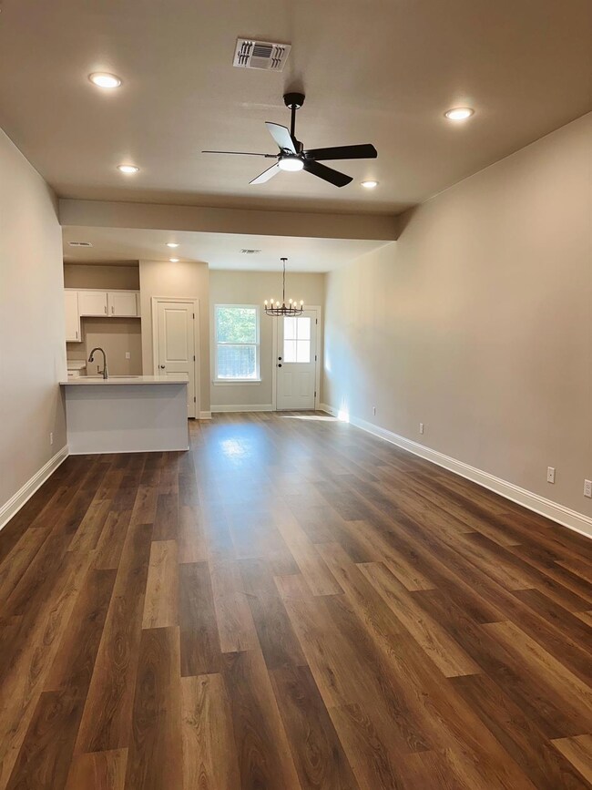 Unfurnished living room with dark wood-type floori