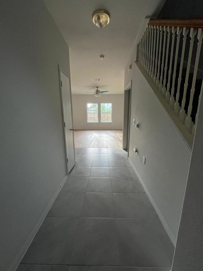 Corridor featuring tile patterned floors, baseboa
