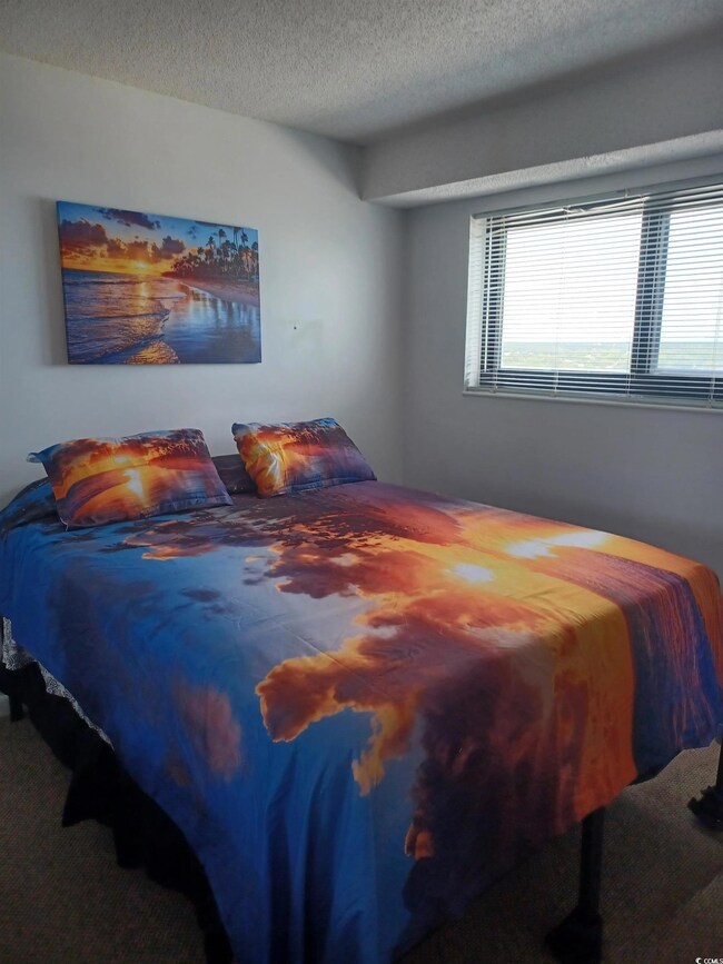 Bedroom with carpet and a textured ceiling