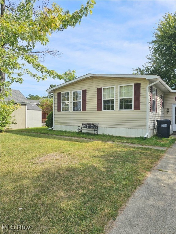 View of front facade featuring an outdoor structure and a front lawn