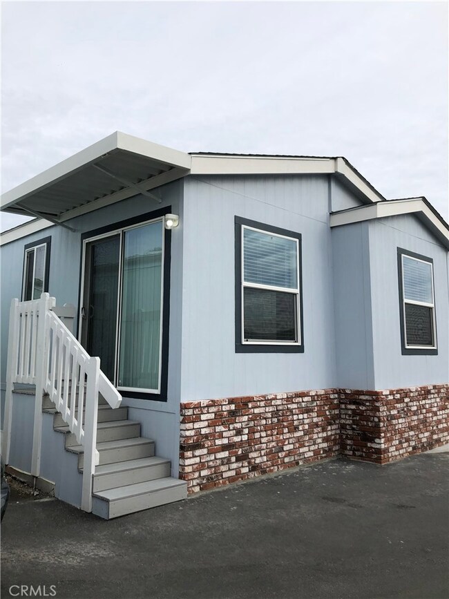 Front of the house with stairways into the dining area and living room.