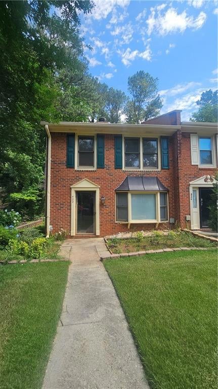 View of front of house featuring a front yard and brick siding