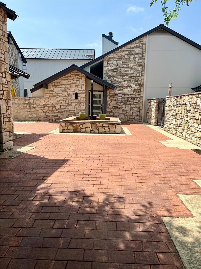 Rear view of property featuring stone siding, a p