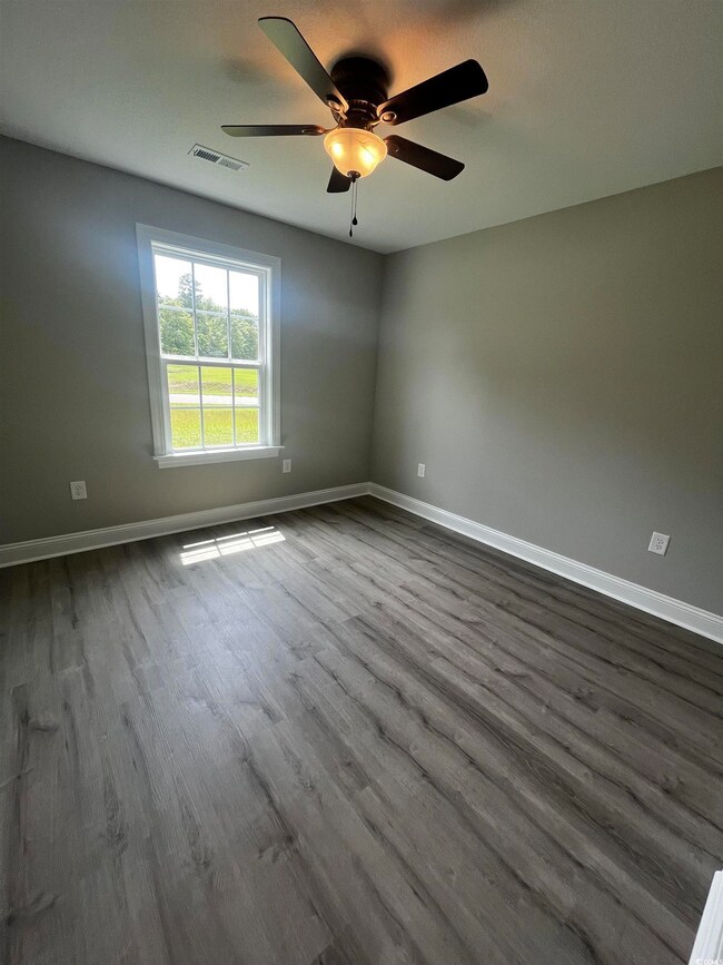 Spare room with ceiling fan and hardwood / wood-st