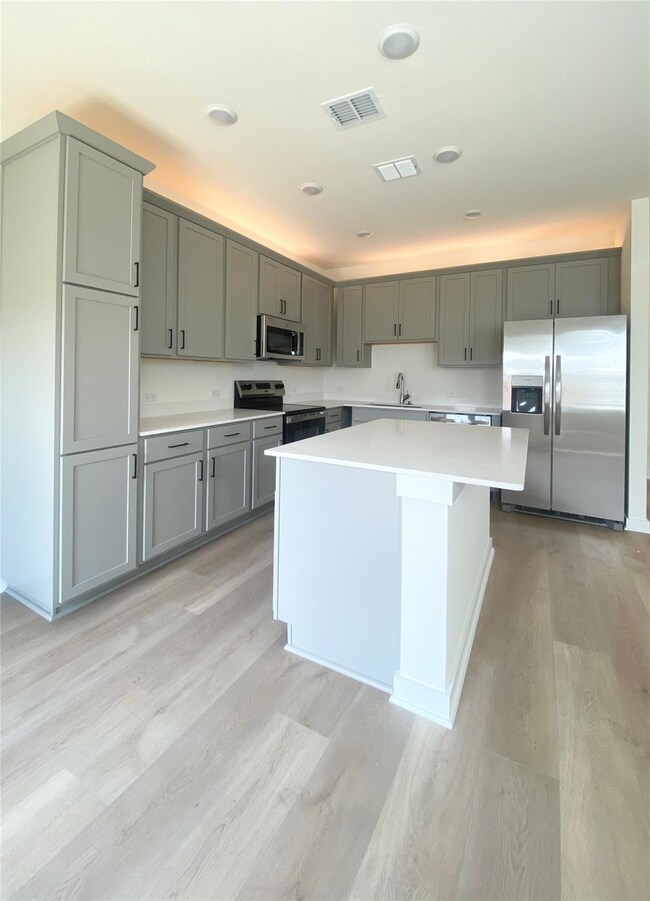 Kitchen featuring stainless steel appliances, lig