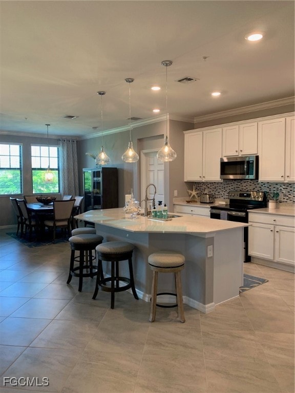 Kitchen with a center island with sink, pendant lighting, sink, and a breakfast bar area