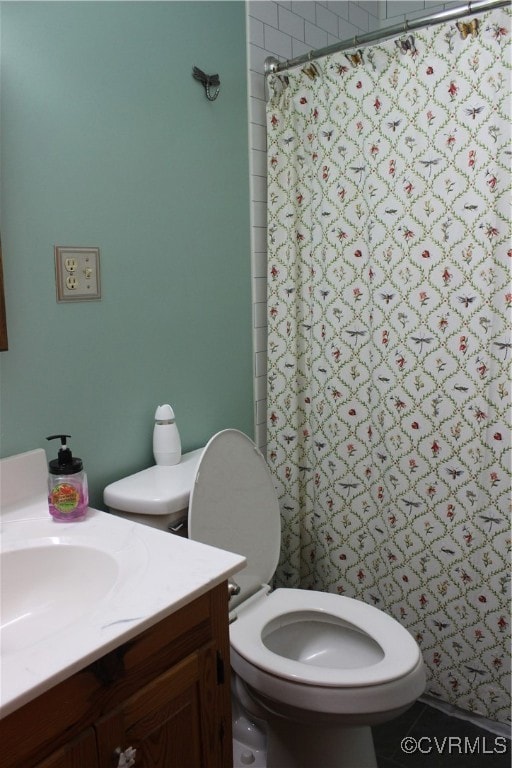 Full bath featuring toilet, vanity, and curtained