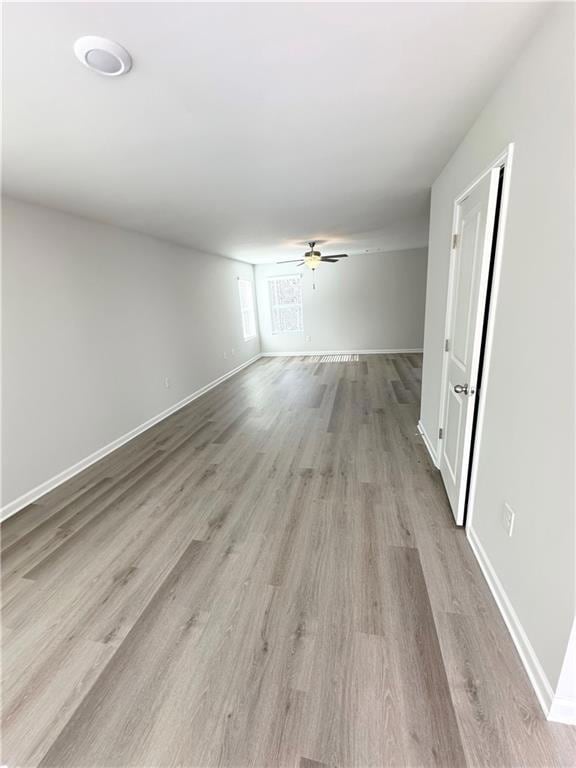 Spare room featuring baseboards, ceiling fan, and wood finished floors