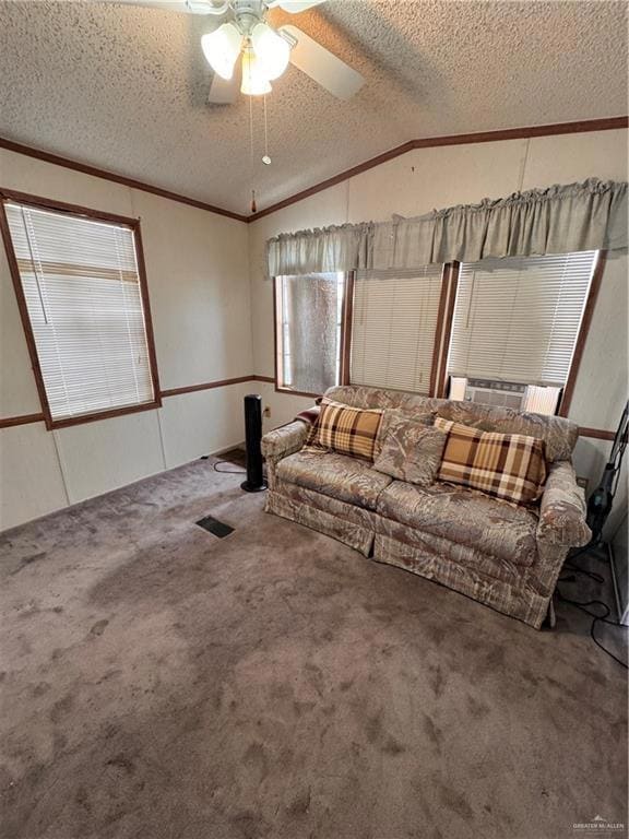 Carpeted living room with a textured ceiling, lofted ceiling, ornamental molding, ceiling fan, and cooling unit