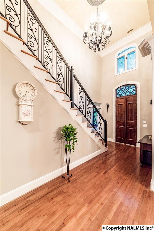 Beautiful iron railings and chandelier make for a dramatic and impressive entry space