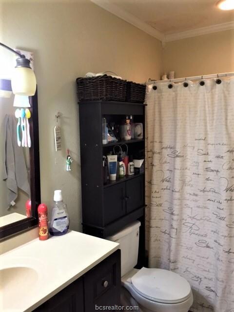 Bathroom featuring vanity, ornamental molding, cur