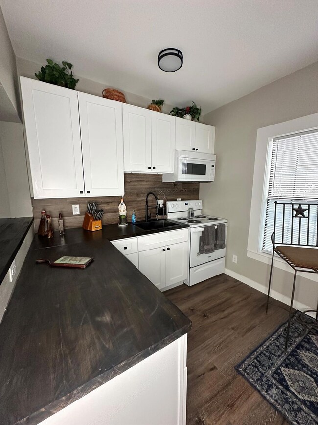Kitchen featuring sink, white cabinetry, tasteful 
