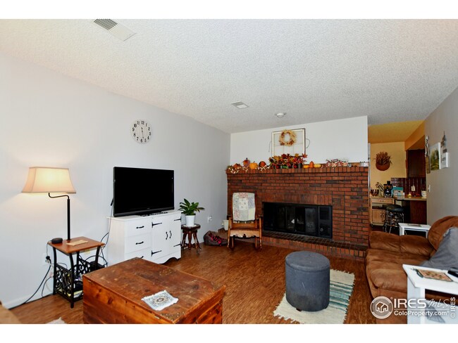 Living room features laminate wood floors and wood burning fireplace