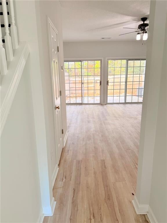Corridor featuring light wood finished floors