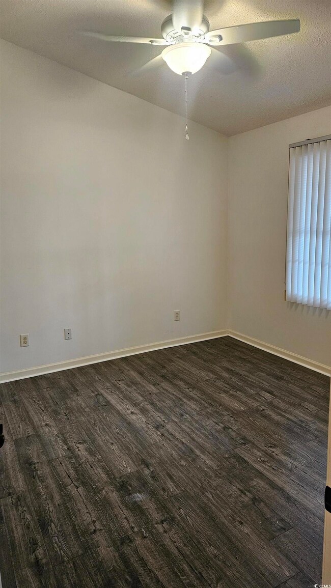 Unfurnished room featuring a textured ceiling, dar