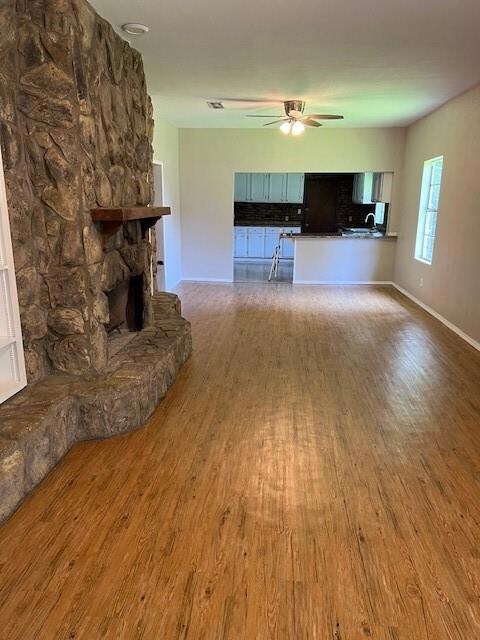 Unfurnished living room with a stone fireplace, si