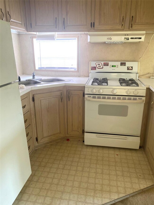 Kitchen with white appliances, exhaust hood, ligh