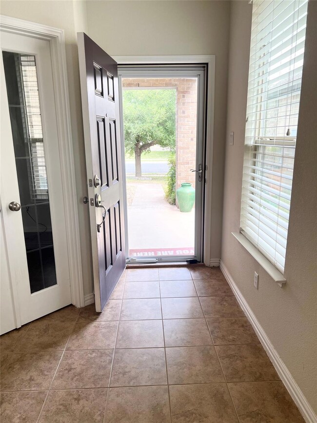 Tiled entryway featuring baseboards