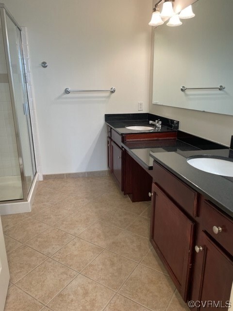 Bathroom featuring a shower, dual sinks, vanity ar