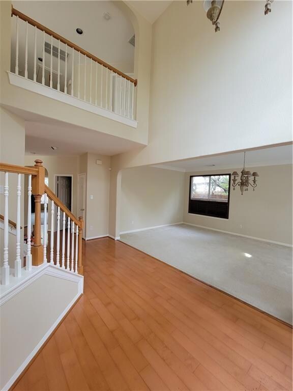 Unfurnished living room featuring a towering ceil
