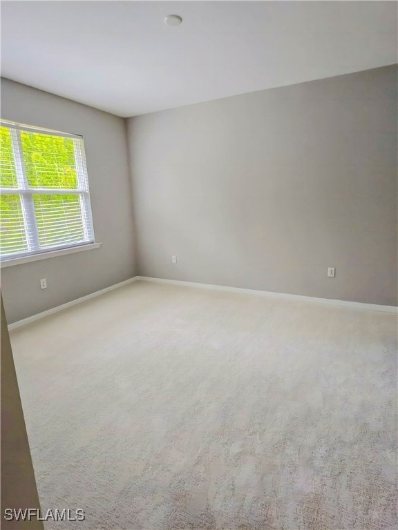 Carpeted empty room featuring baseboards