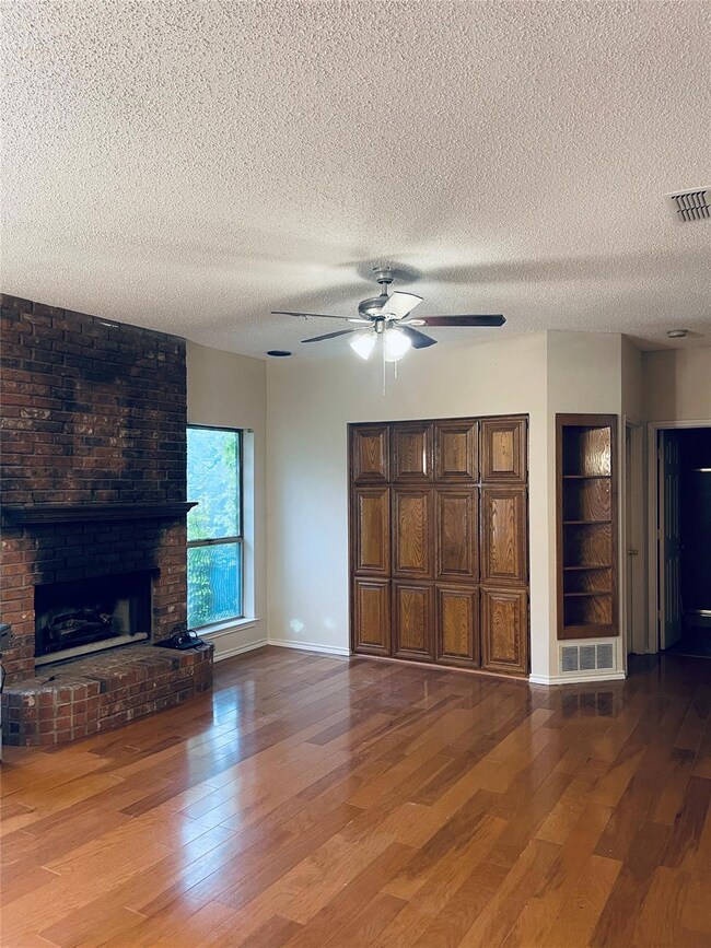 Unfurnished living room featuring a textured ceili
