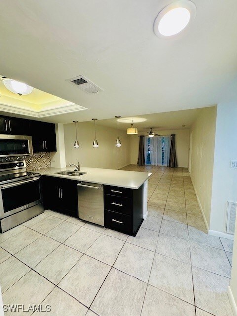 Kitchen with sink, hanging light fixtures, applian