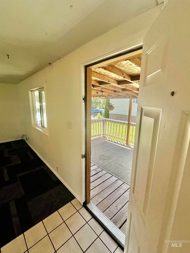 Doorway with light tile patterned floors
