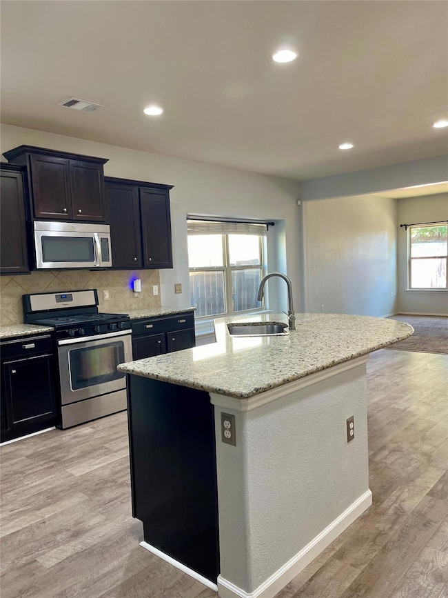 Kitchen with stainless steel appliances, light wo