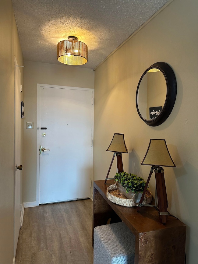 Entrance foyer with a textured ceiling and wood finished floors