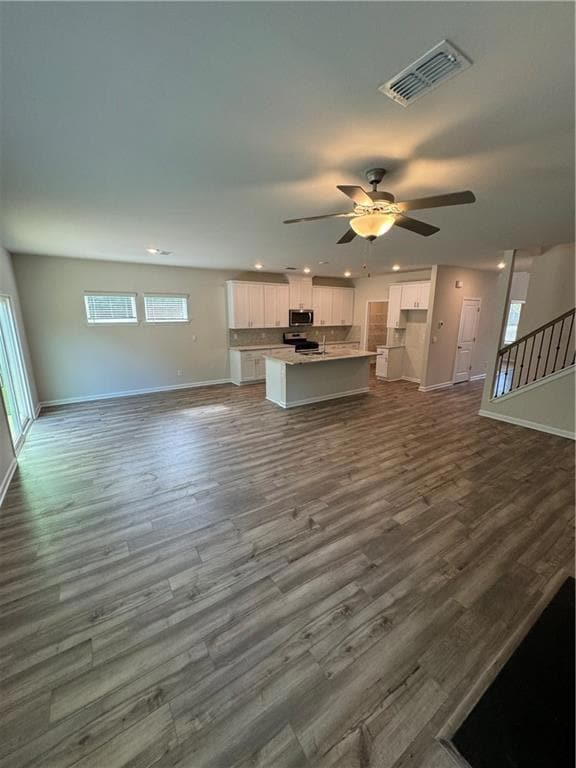 Unfurnished living room with recessed lighting, dark wood-type flooring, and a ceiling fan