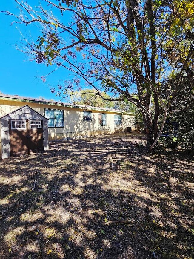 View of side of home with a storage shed