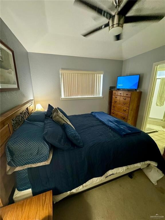 Bedroom featuring carpet flooring, connected bathroom, and ceiling fan