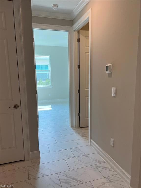 Hallway featuring ornamental molding, light marble