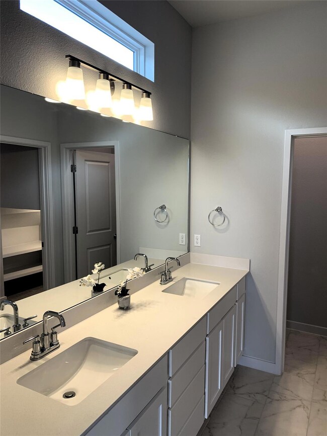 Bathroom featuring marble look tiles, baseboards,