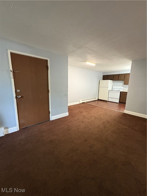 Unfurnished living room with dark carpet, baseboard heating, and a textured ceiling