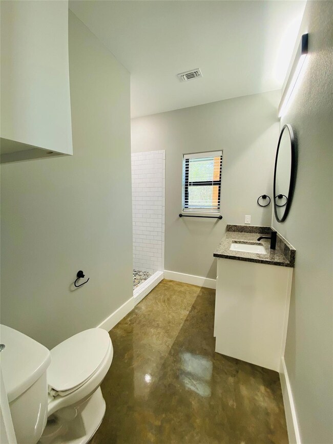 Bathroom featuring concrete floors, walk in shower