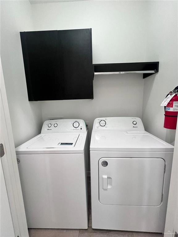 Laundry room with washing machine and clothes dryer and cabinets